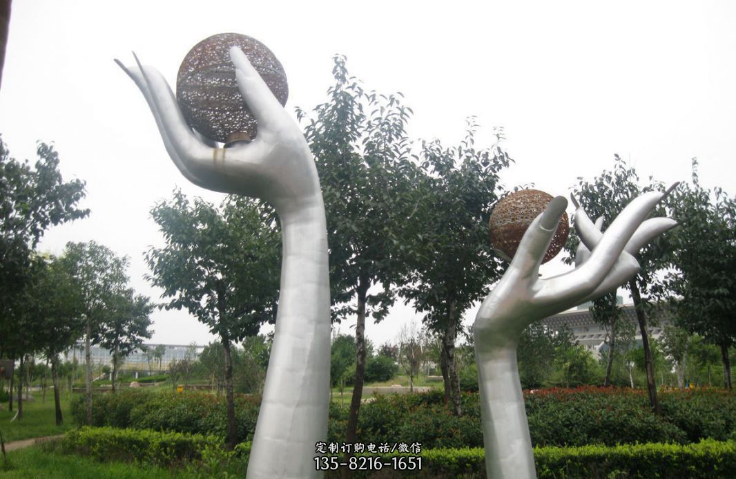 公园不锈钢拿着镂空球的手雕塑
