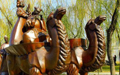 公园景区摆放的两只驮着小孩的玻璃钢仿铜创意骆驼雕塑