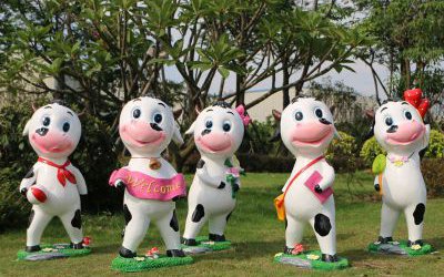 园林一群游玩的玻璃钢卡通奶牛雕塑