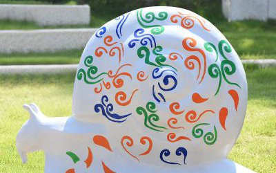 景区草坪摆放的白色彩绘玻璃钢蜗牛雕塑