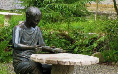 玻璃钢仿铜公园里男孩坐着凳子上的读书雕塑
