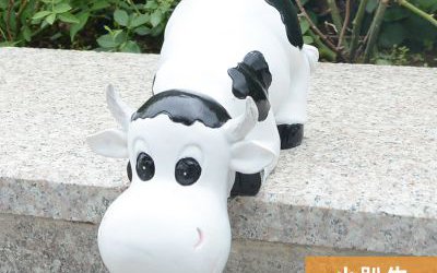 园林一只趴着的玻璃钢卡通奶牛雕塑