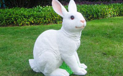 小区草坪中一只白色玻璃钢兔子雕塑