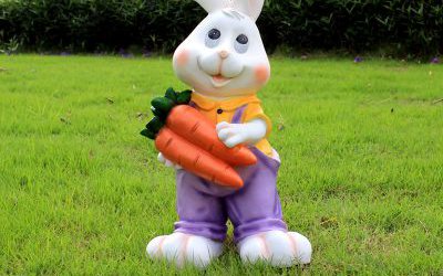 草坪一只抱着胡萝卜的玻璃钢卡通兔子雕塑