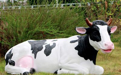 池塘边一只握着休息的玻璃钢仿真奶牛雕塑