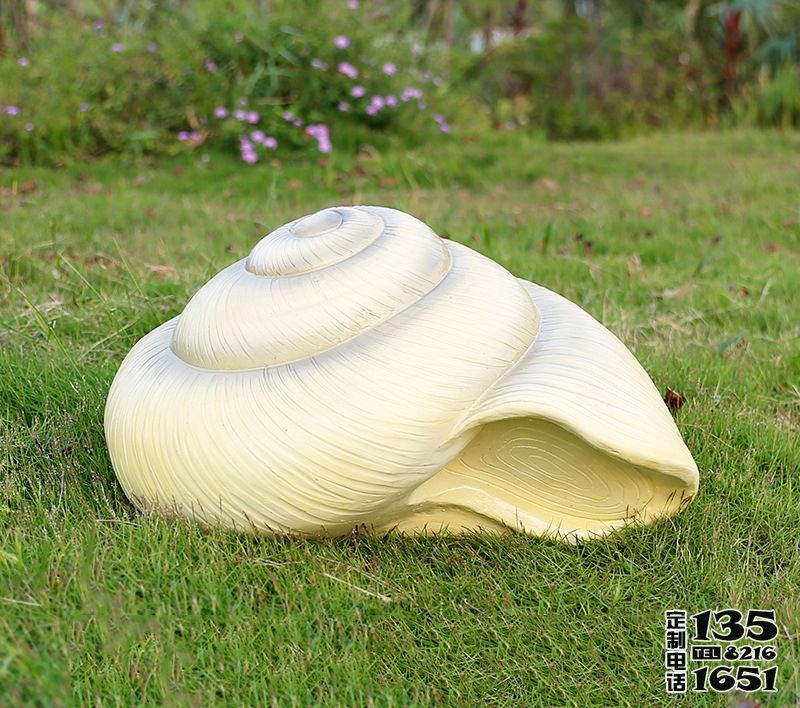草地上摆放的圆形的玻璃钢仿真海螺雕塑