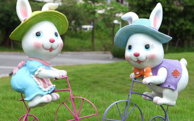 公园玻璃钢骑自行车的卡通兔子雕塑