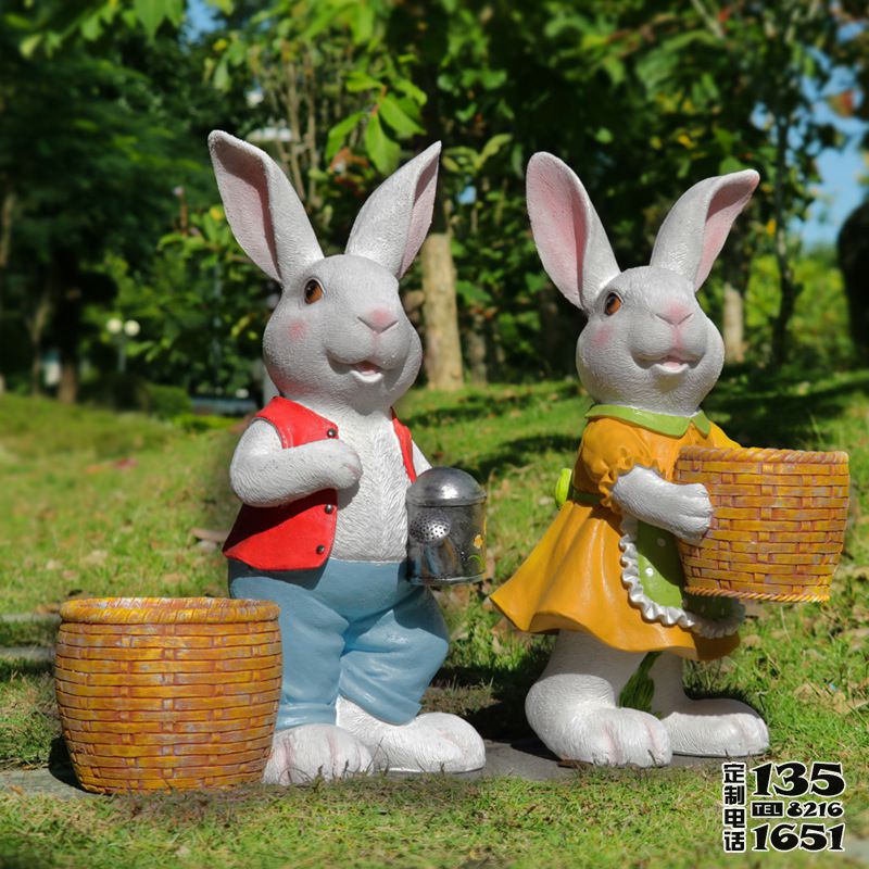 森林草坪里两只玻璃钢卡通兔子雕塑