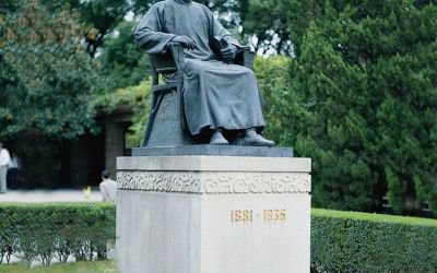 公园广场大型景观坐着石柱上面的玻璃钢鲁迅雕塑