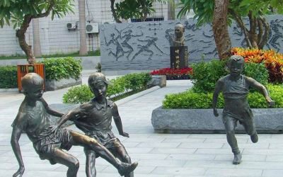 公园景观玻璃钢仿铜小孩踢足球雕塑