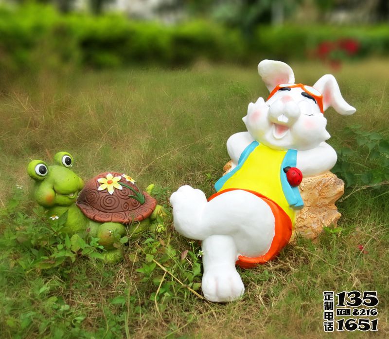公园草坪上玻璃钢卡通休息的兔子和乌龟雕塑