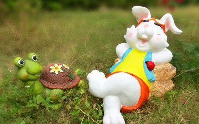 公园草坪上玻璃钢卡通休息的兔子和乌龟雕塑