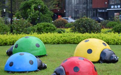 公园里摆放的四只爬行的玻璃钢彩绘七星瓢虫雕塑