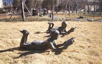 校园草坪玻璃钢仿铜趴着读书的儿童雕塑