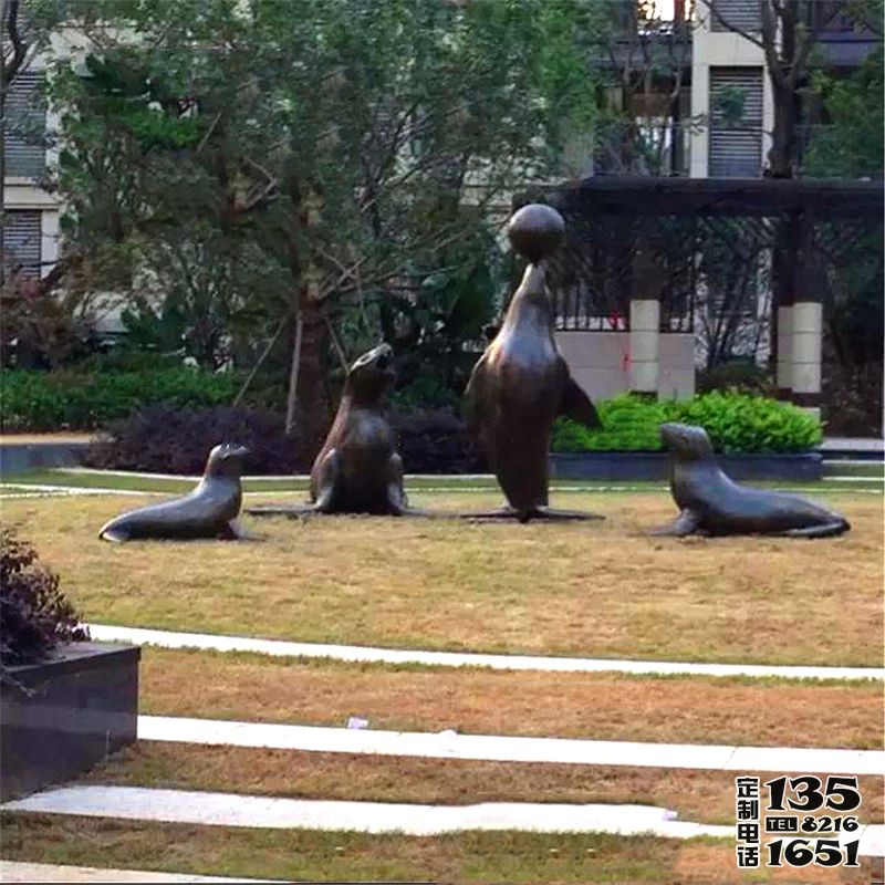 公园草坪上摆放的贪玩的玻璃钢仿铜海豹雕塑