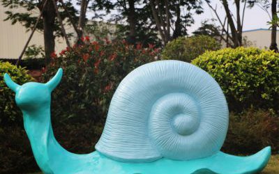 草地上摆放的一只蓝色玻璃钢彩绘蜗牛雕塑