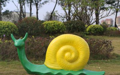 草地上摆放的中号的绿色玻璃钢彩绘蜗牛雕塑