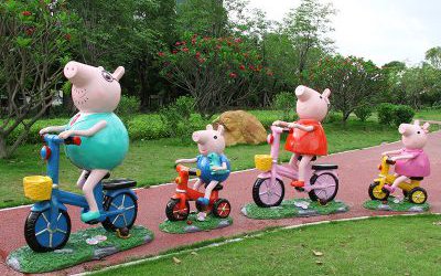 学校公园草坪摆放骑自行车的卡通小猪佩奇一家玻璃钢雕塑