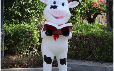 校园摆放一只看书的玻璃钢卡通奶牛雕塑